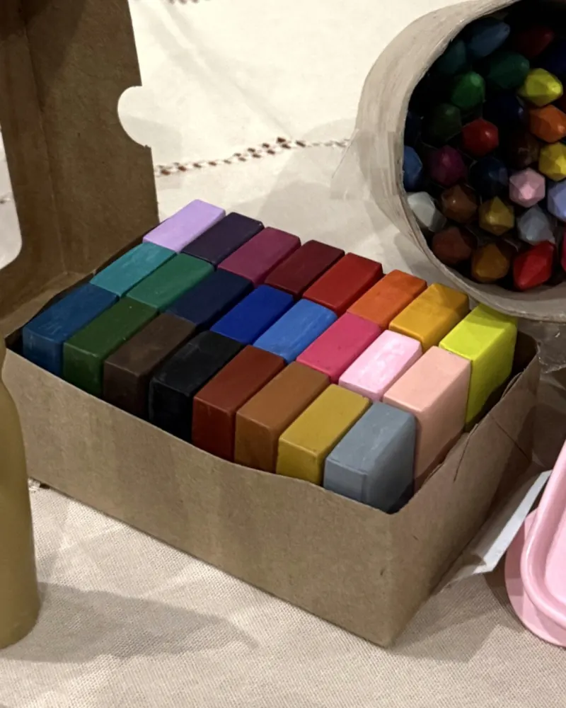 Blocos de giz de cera de abelha na caixa kraft, em tons de azul, verde, vinho, rosa, laranja, amarelo e cinza