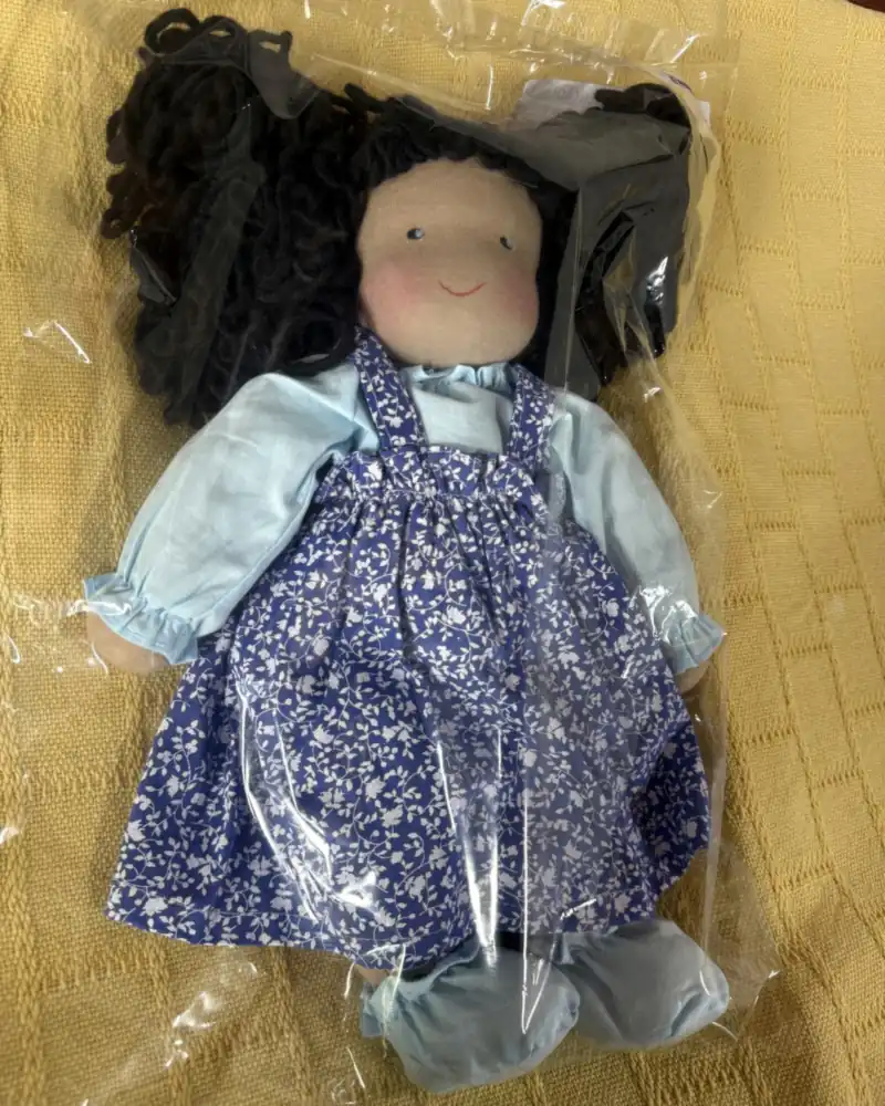 Morena Rosa de frente, ainda no saquinho de embalagem, com bochechas rosadas e sapatinhos azul-claros